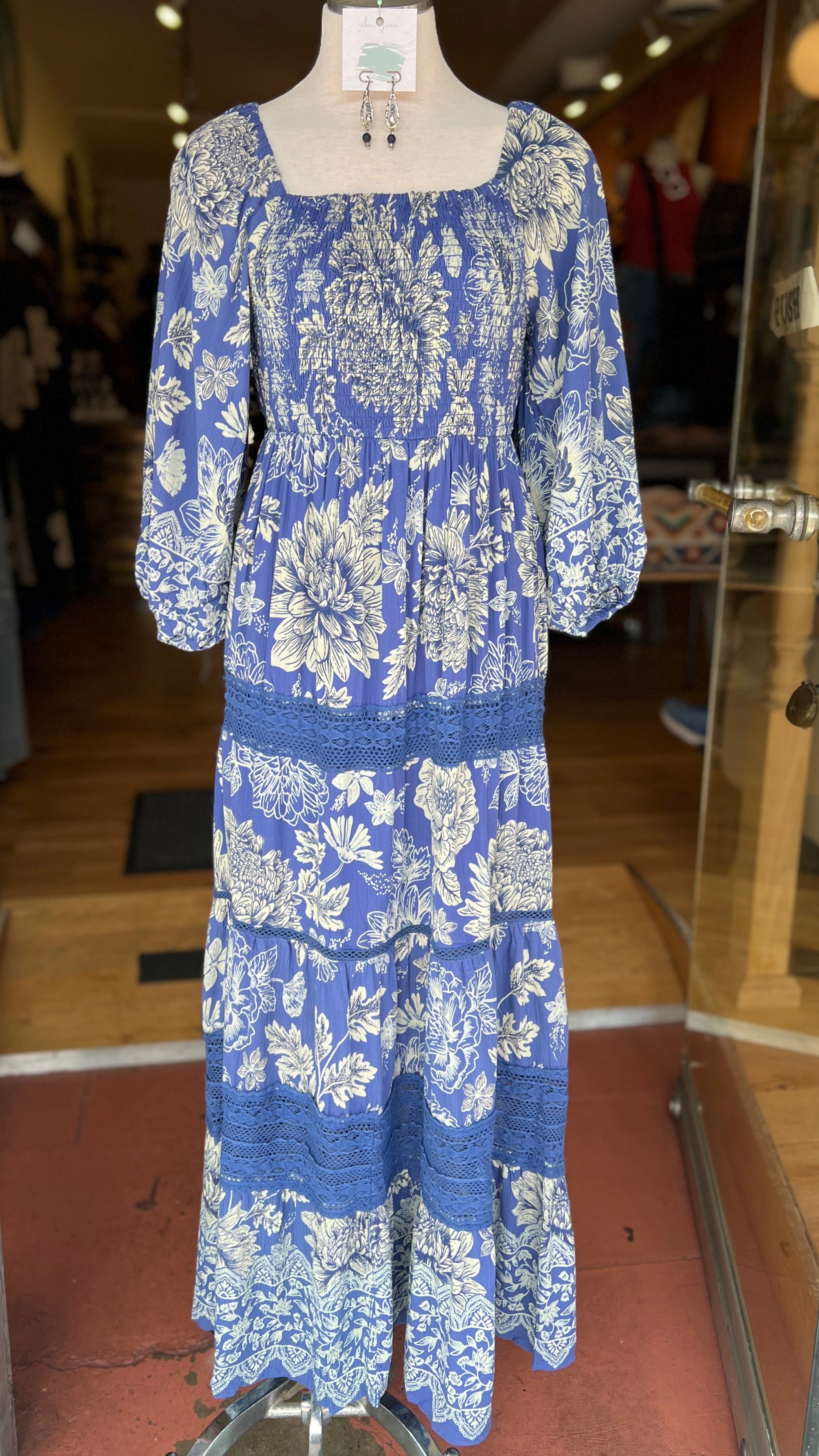 Blue floral dress on a mannequin in a store setting