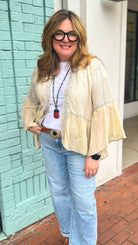 Woman standing on a brick sidewalk in front of a building with a light blue wall.