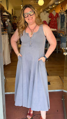 Woman in a light blue jumpsuit standing in a clothing store.