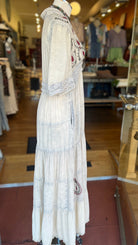 White embroidered dress on a mannequin in a store setting