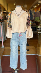 Mannequin wearing a floral top and jeans in a store setting