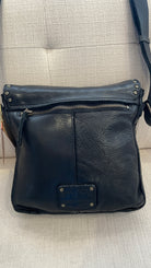 Black leather bag with visible brand logo on a light gray background